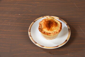 typical brazilian food baked empada stuffed with chicken meat and sauce isolated on the table