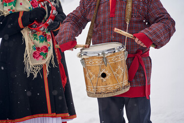  playing the drums in close-up in national costumes