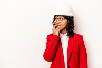 Young architect hispanic woman with helmet isolated on white background relaxed thinking about something looking at a copy space.