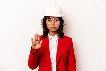 Young architect hispanic woman with helmet isolated on white background standing with outstretched hand showing stop sign, preventing you.