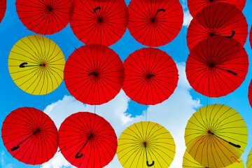 Fototapeta na wymiar Umbrella background. Multicolored parasols hanging in sky bottom- up. Street decoration