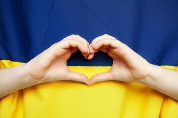Hands in heart form on Ukrainian flag background, colors - yellow and blue. Independence day of Ukraine, Flag, Constitution day Education, school, Love Ukraine, Pray for Ukraine, no war concept