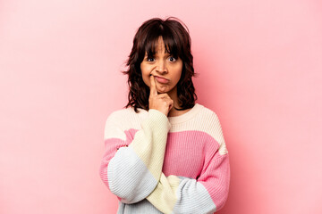 Young hispanic woman isolated on pink background unhappy looking in camera with sarcastic expression.