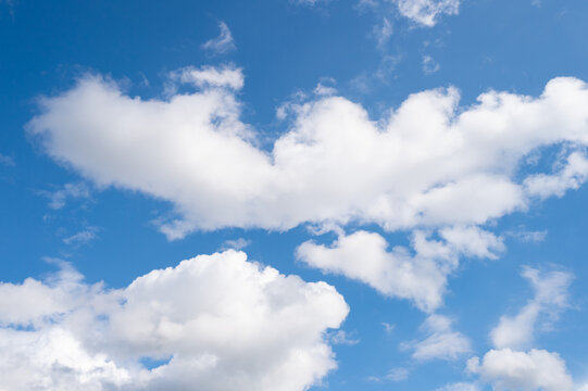 Cloudscape with white cumulus tufted clouds on cloudy blue sky background