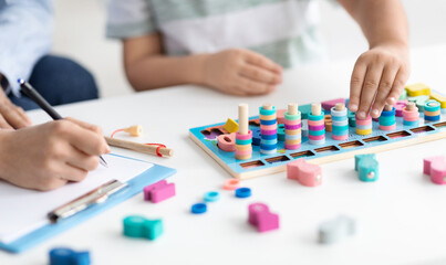 Modern organic toys for kids. Unrecognizable little boy playing developing wooden game,...