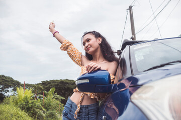 A young confident woman in a happy mood. Smiling about the new car she bought.