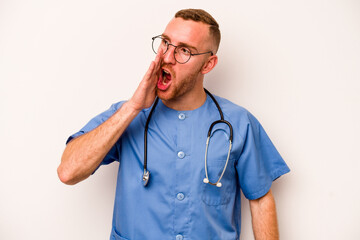 Young caucasian nurse man isolated on white background shouting and holding palm near opened mouth.