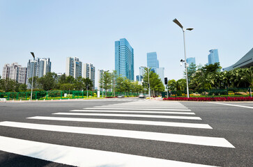 Empty road with zebra crossing and skyscrapers