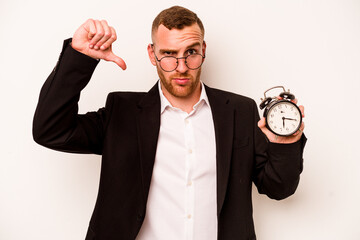 Young business caucasian man holding alarm clock isolated on white background showing a dislike...