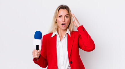 blonde pretty woman looking happy, astonished and surprised. preporter and microphone concept