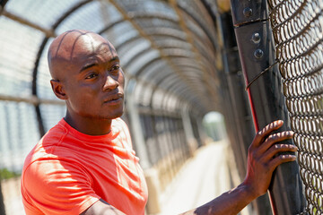 Fototapeta na wymiar African American male looking though fence after exercising