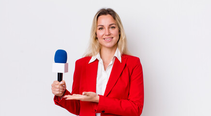 blonde pretty woman smiling cheerfully, feeling happy and showing a concept. preporter and...