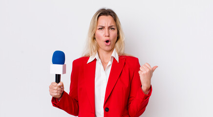 blonde pretty woman looking astonished in disbelief. preporter and microphone concept