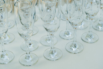 Rows of champagne glasses aligned neatly on white table, preparing for the ceremony or party.