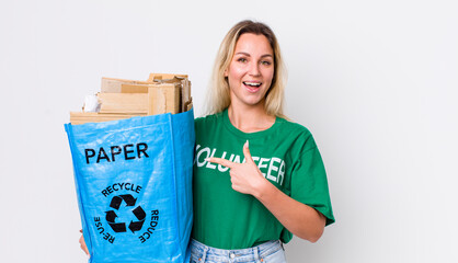 blonde pretty woman looking excited and surprised pointing to the side. recycle concept