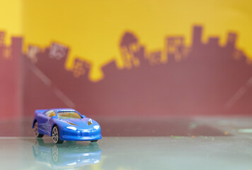 blue Saloon car toy selective focus on blur city background