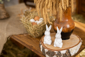 Rabbit figurines. Easter decor on a wooden background