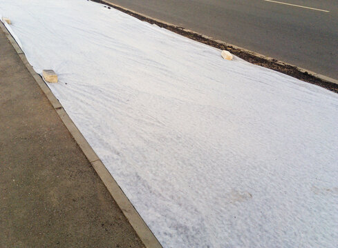 Lawn near the roadway, covered with covering material