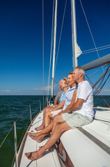 Retired friends enjoying luxury outdoor lifestyle on yacht