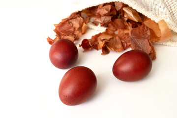 Red Easter eggs and bag with onion husks view from above. Dyeing eggs with onion husks.