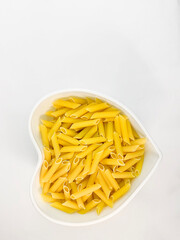 Food concept, top view. Dry pasta in a white plate close-up