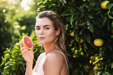 Beautiful woman with smooth skin with a grapefruit in her hands