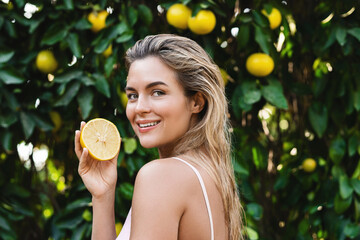 Beautiful woman with smooth skin with a lemon fruit in her hands