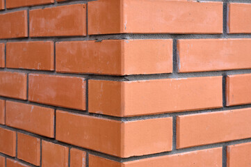 Bricks wall with different orange tones to be used as a background texture, digital graffiti or construction industry example. It is an image that shows solidity, strength, the human capacity.