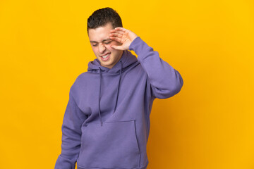 Young caucasian man isolated on yellow background with tired and sick expression