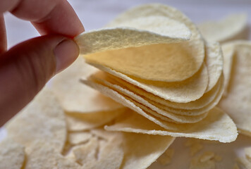 close-up view of a hand picking potato chips
