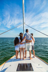 Young Hispanic family standing together on luxury yacht