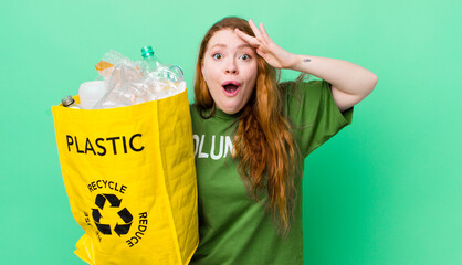 red head pretty woman looking happy, astonished and surprised. recycling concept