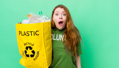 red head pretty woman looking very shocked or surprised. recycling concept
