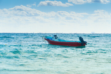 Empty motor boat on a rope. The fishing boat is moored to the shore. Lonely ship on the sea waves.