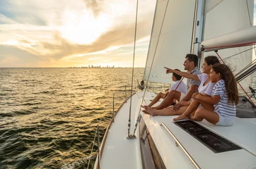 Wandaufkleber Latino family enjoying fun sailing adventures at sunrise © Spotmatik