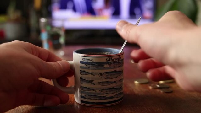 Touiller son caf&eacute; le matin devant le t&eacute;l&eacute;vision