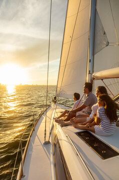 Hispanic family enjoying ocean sunset from luxury yacht
