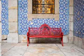 Portugal, Porto, Red bench in front of wall covered with azulejos