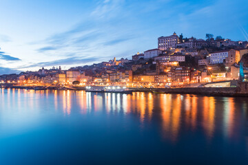 Obraz premium Portugal, Porto, Duoro river and old town buildings illuminated at dusk