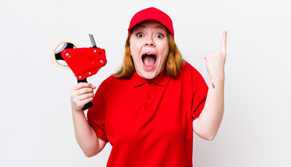 red head pretty woman feeling like a happy and excited genius after realizing an idea. packer...