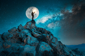 man standing on the rock outdoors under the starry night and full Moon