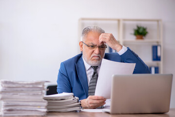 Fototapeta premium Old male employee and too much work in the office