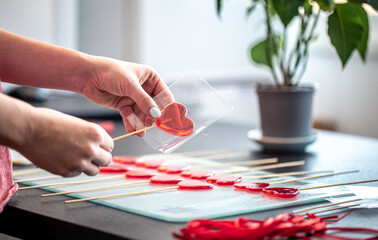 Fototapeta na wymiar Packaging of red lollipops in the shape of hearts.