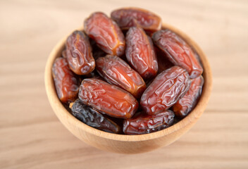 Date fruit in bowl on wooden background,directly above