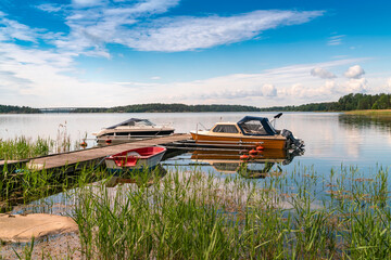 Sweden, Loftahammar, Boats moored at small pier on calm sea © Image Source RF