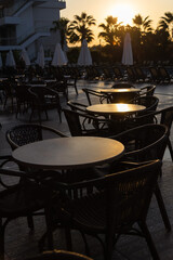 tables in a Turkish street cafe in the early morning light against the backdrop of palm trees