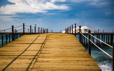 wooden pier in the mediterranean sea on a clear sunny day, view from below, perspective - 495503561