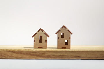 Two wooden small houses with windows on a light background