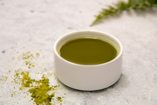 The ceremony of traditional green tea matcha in a bowl on a concrete table. Top view. Space for text.