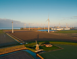 Netherlands, Eemshaven, Aerial view of wind turbines and windmill in field